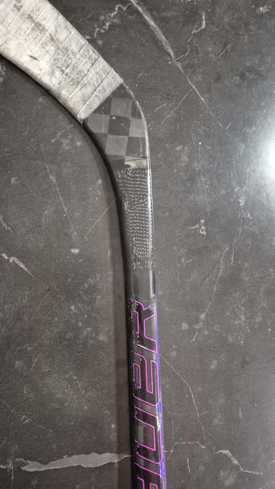 Korjattu jääkiekkomailan alavarsi. Jääkiekkomaila joka on korjattu alavarresta